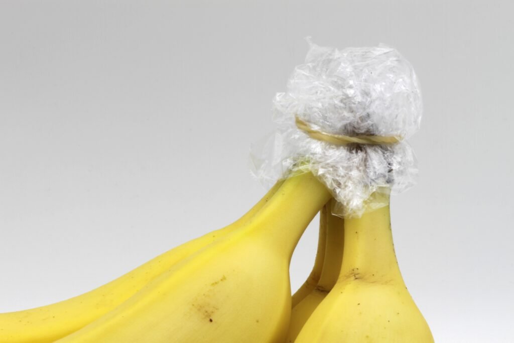 Banana bunch with stems wrapped in plastic wrap