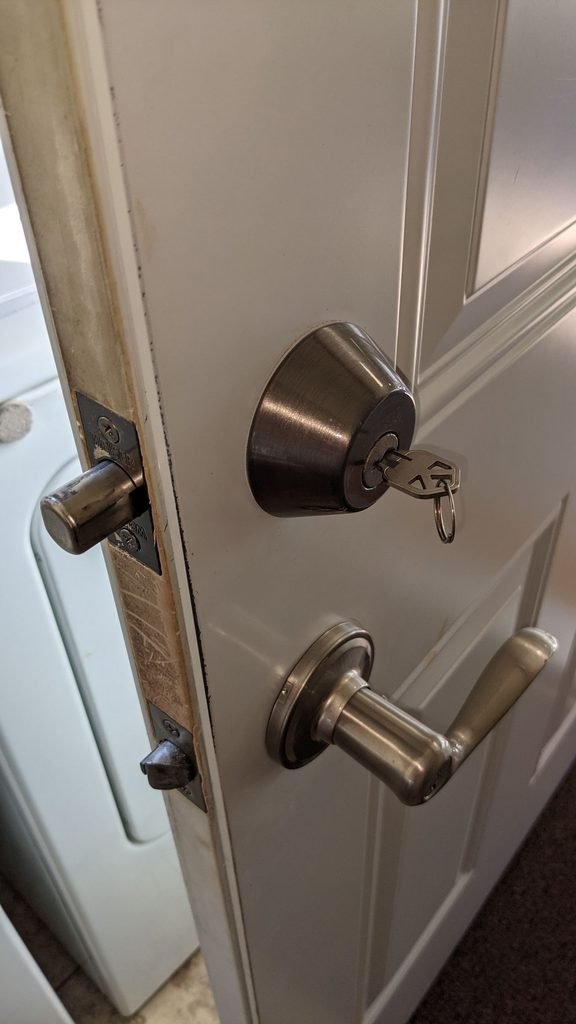 Door latch, deadbolt and strike plate visible on an interior door frame