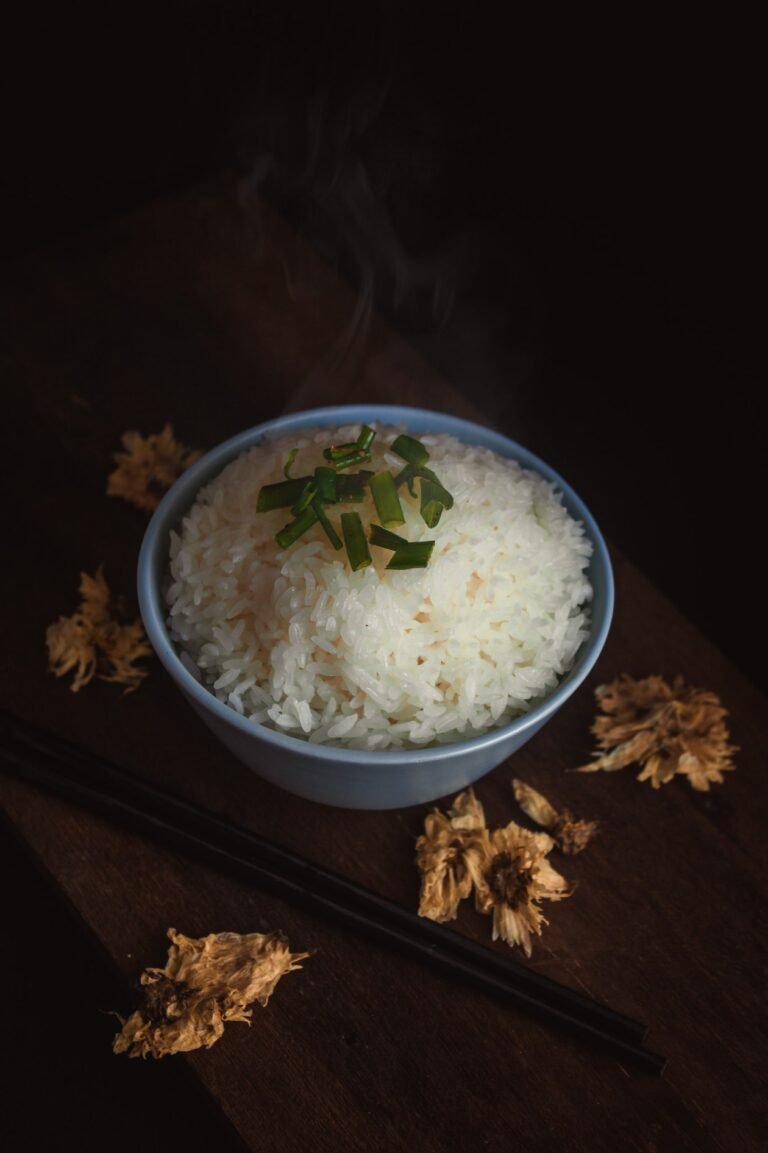 Steaming bowl of freshly cooked white rice with chopsticks