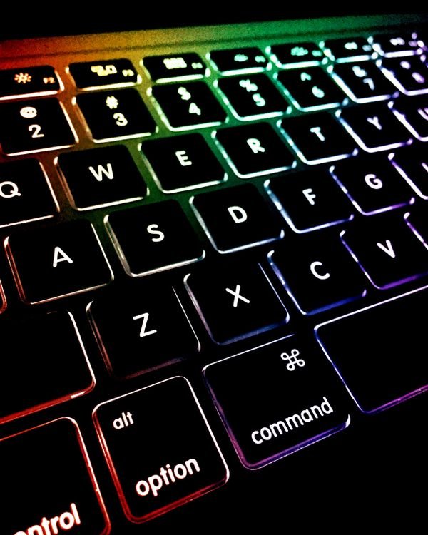 Why Does My Laptop Get Hot and Shut Down? 9 Fixes That Work Close up of a backlit laptop keyboard glowing with rainbow colors