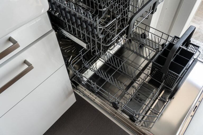 Open empty dishwasher showing pull out racks