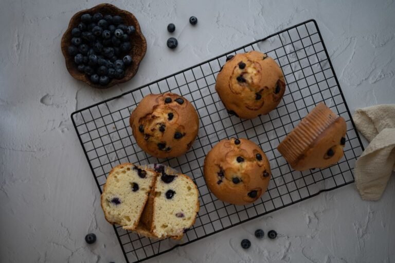Blueberry muffins cooling on a wire rack with paper liners