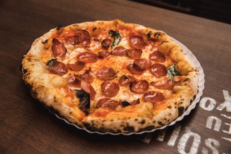 How to Keep Pizza Warm in Oven Without Drying Out: The Foolproof Method Close up of a freshly baked pepperoni pizza with a crisp golden crust on a wooden table