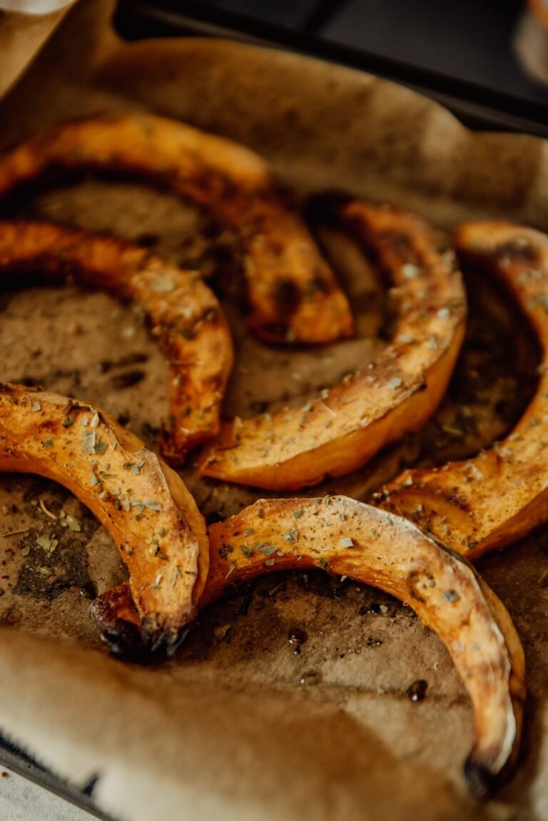 Roasted pumpkin slices with herbs on baking paper ready for puree