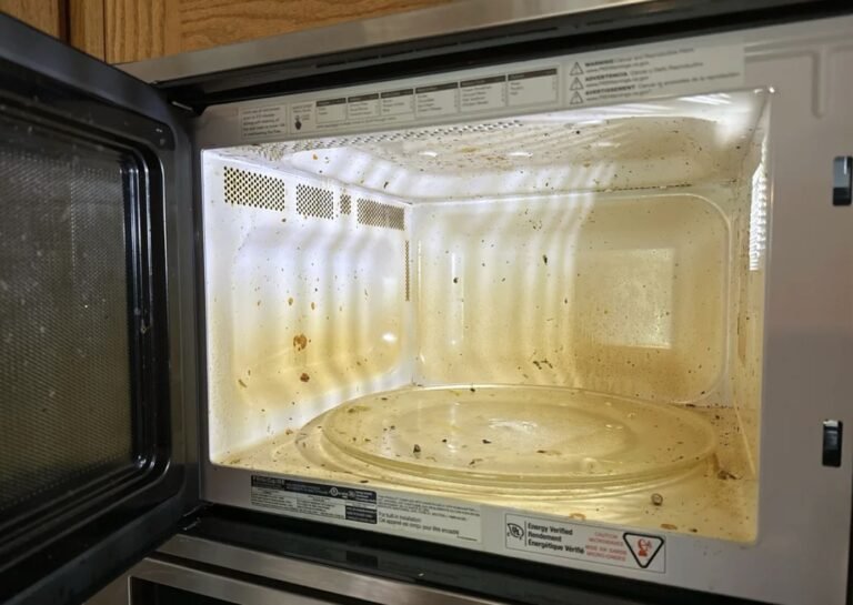 Dirty microwave interior with dried food splatters before cleaning