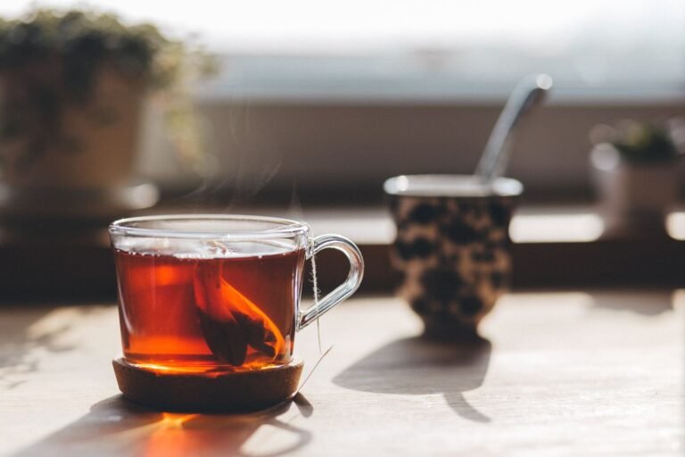 A glass cup of freshly brewed tea on a wooden table