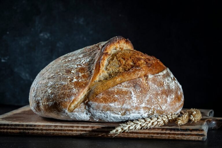 Fresh sourdough loaf resting on a wooden cutting board