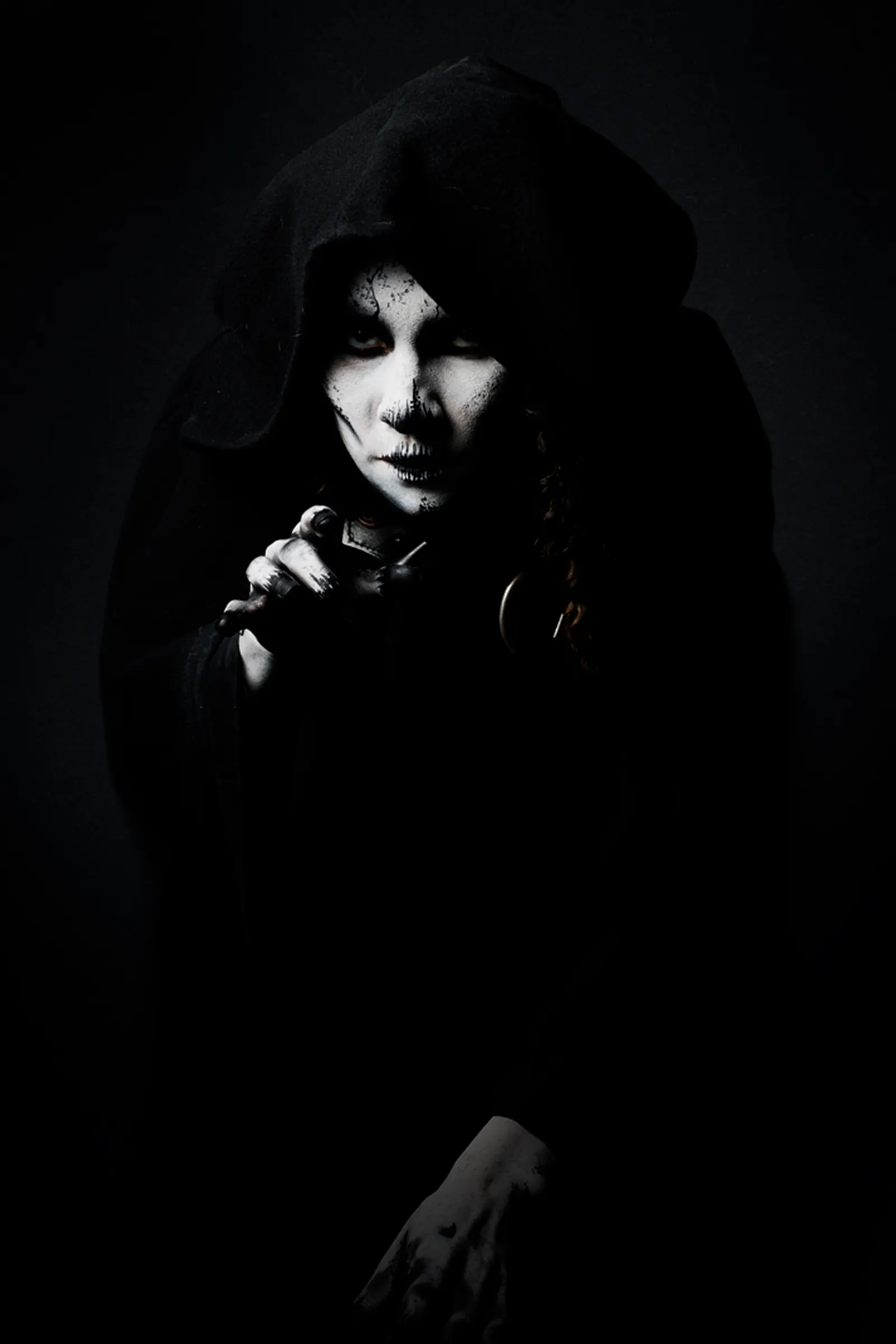Mysterious hooded figure in the dark, like the cloaks worn by Maya Jama and the Traitors in the turret