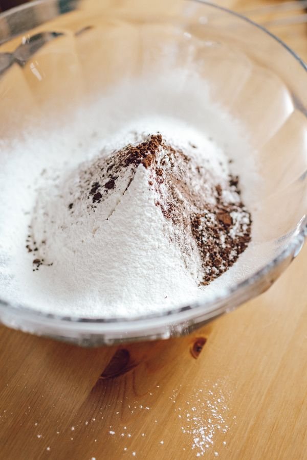 Powdered sugar and cocoa powder in a glass mixing bowl