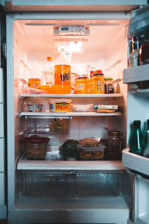 Inside of an open fridge full of jars and containers