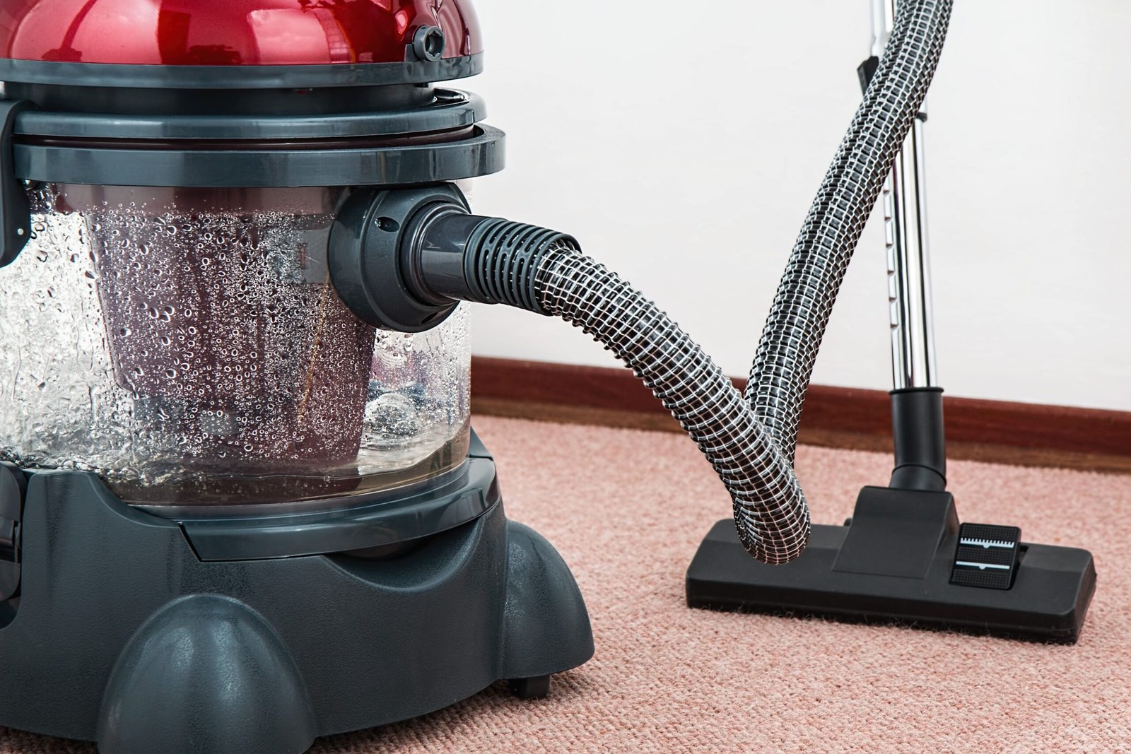 Canister vacuum cleaner with a flexible hose for dust removal