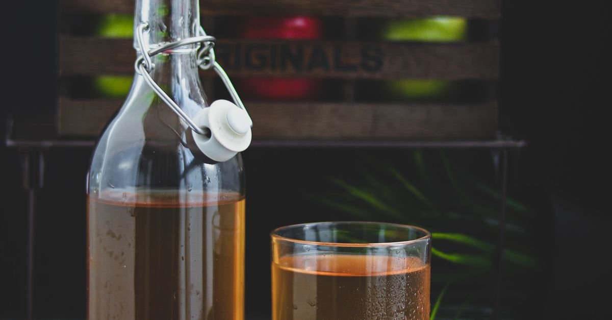 Glass bottle of apple cider vinegar used in a dishwasher cleaning cycle