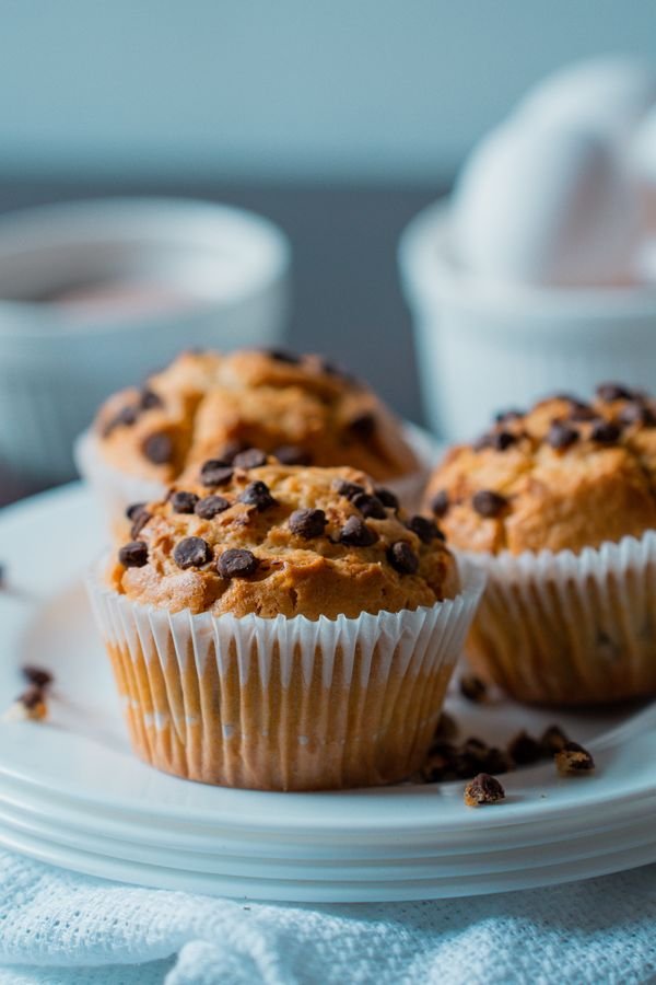 Chocolate chip muffins in paper liners on a white plate
