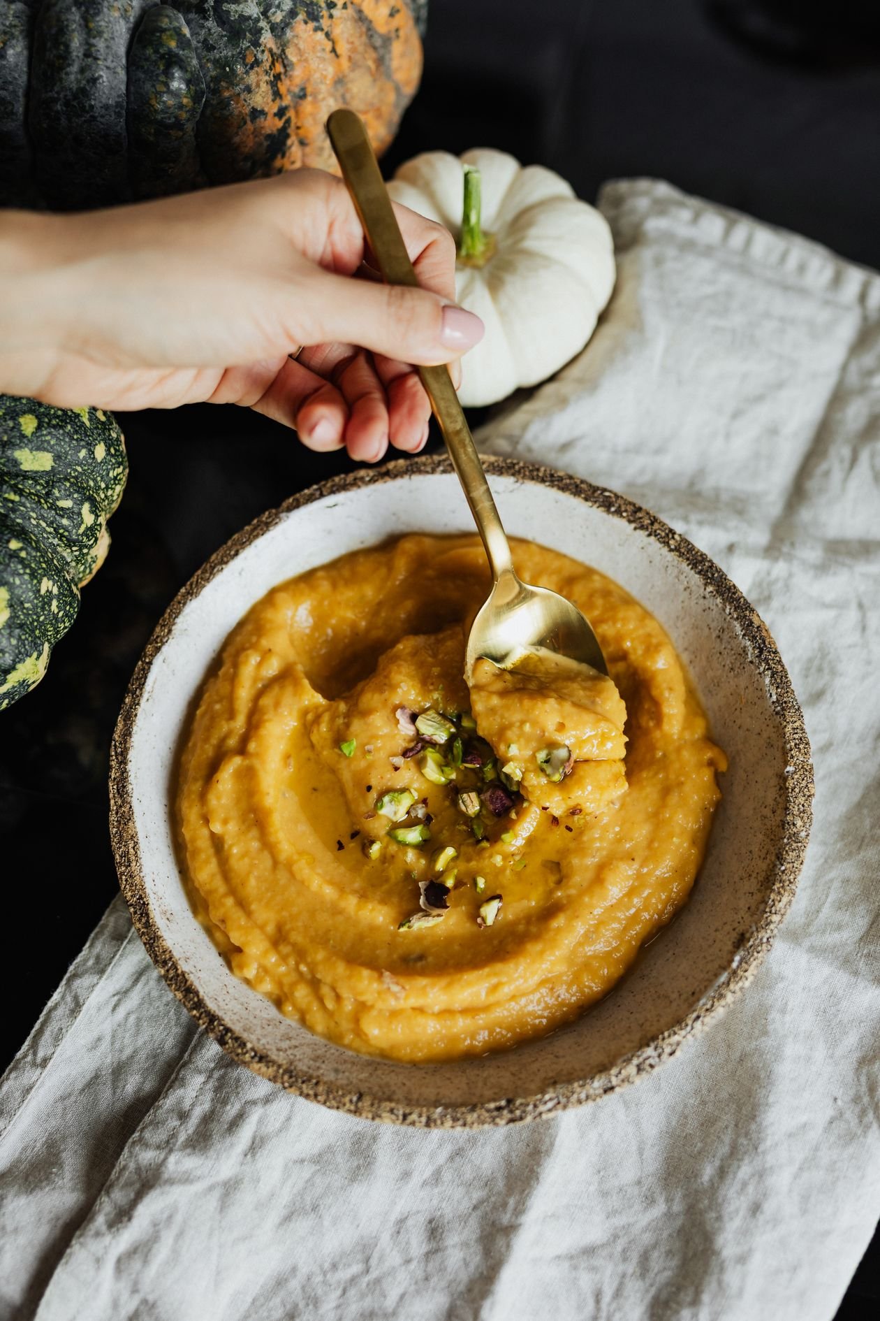 Smooth homemade pumpkin puree in a ceramic bowl with a spoon