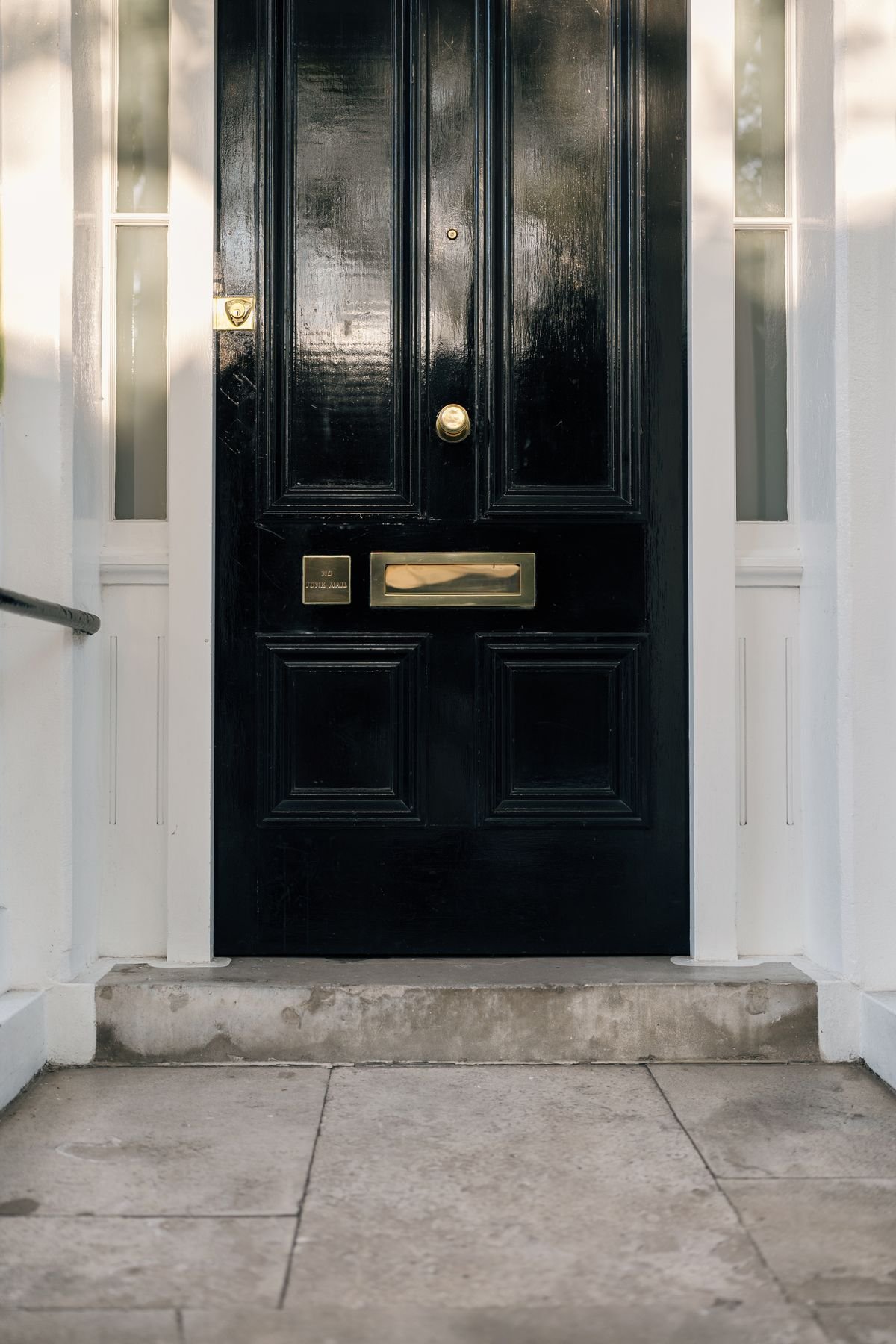 Classic black front door of a London townhouse with brass fittings