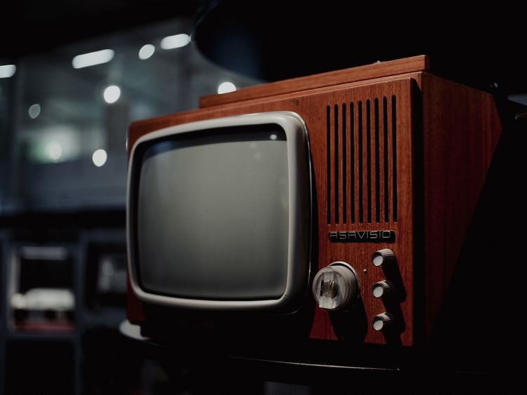 A wooden vintage television set glowing softly, recalling the years of Miranda Hart beloved BBC sitcom