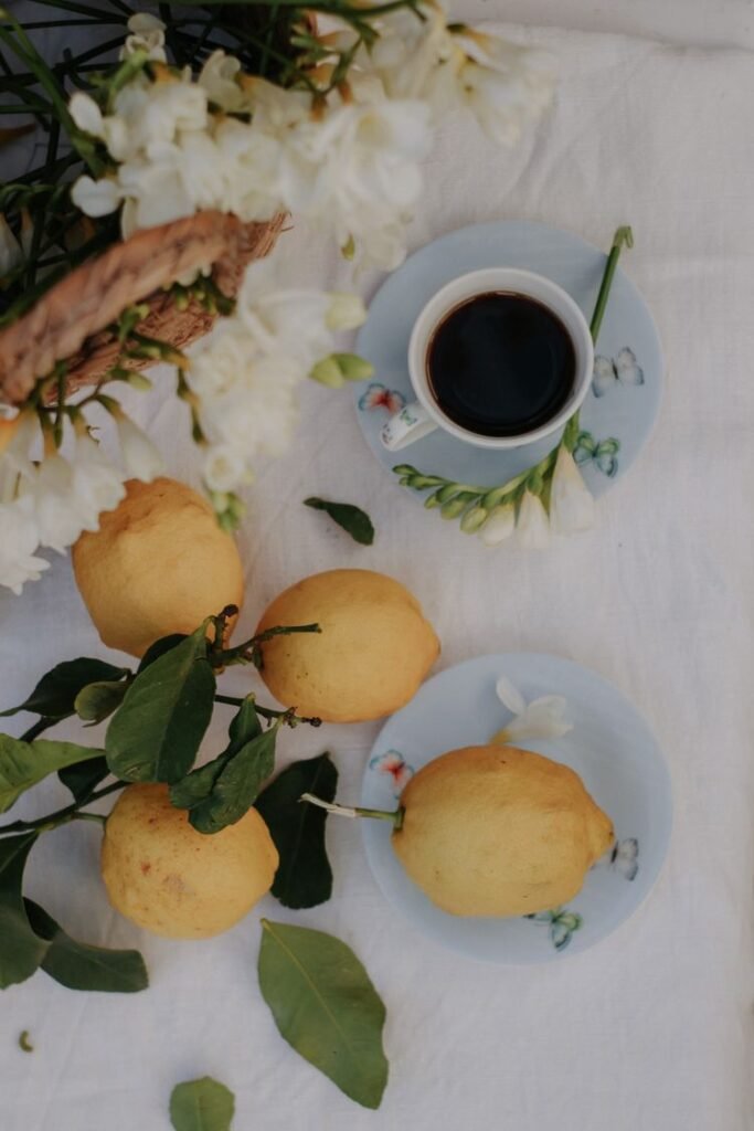 Fresh lemons arranged on a white table with flowers
