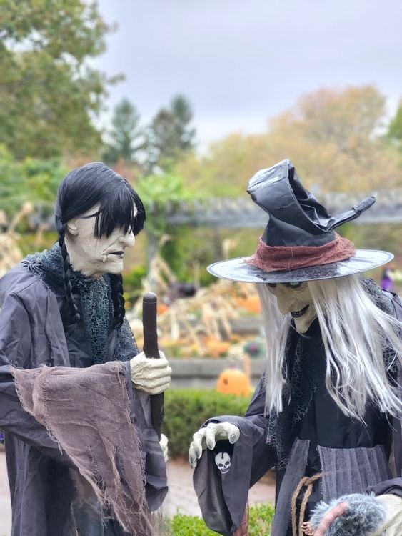 Witch Halloween garden decorations standing in an autumn garden