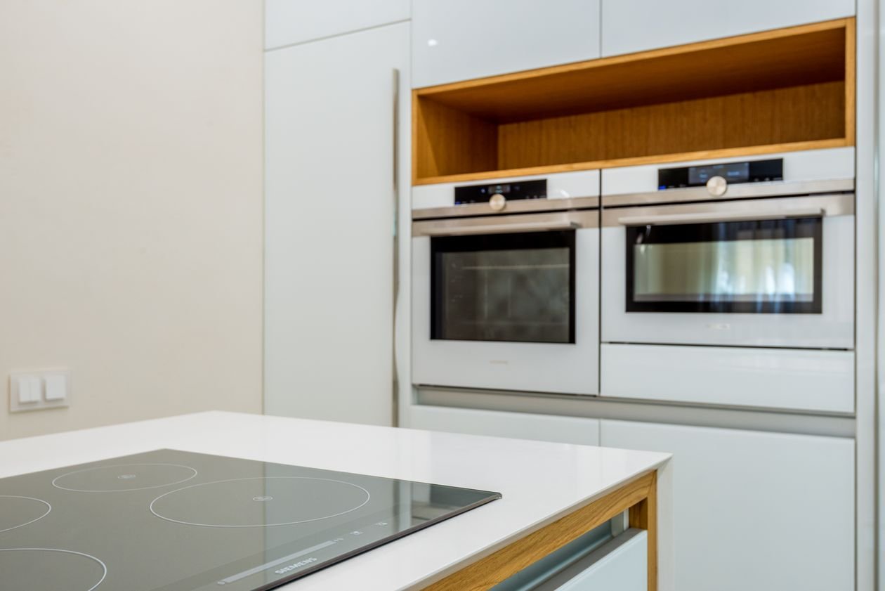 Spotless white double ovens in a modern kitchen after cleaning