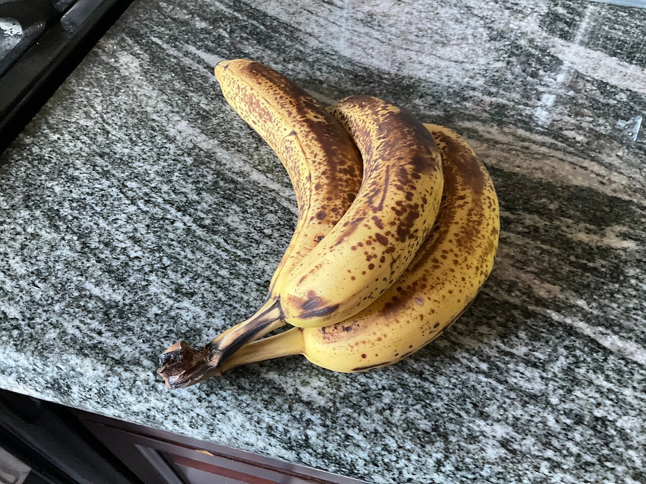 Overripe brown spotted bananas on a kitchen counter