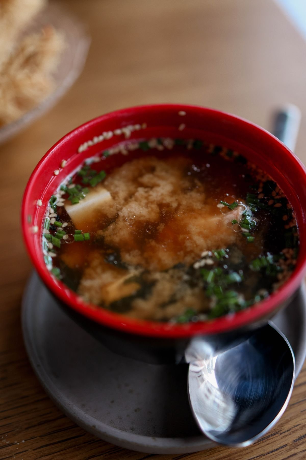 Red miso soup with tofu cubes in a red bowl