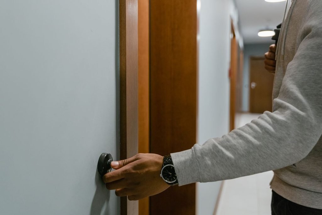 Person turning a round doorknob to test that an interior door closes and latches