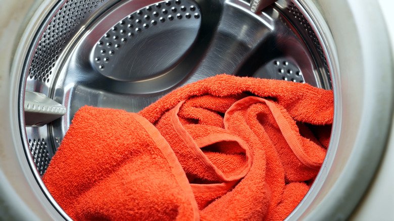Towels tumbling inside a front loading washing machine during a wash cycle