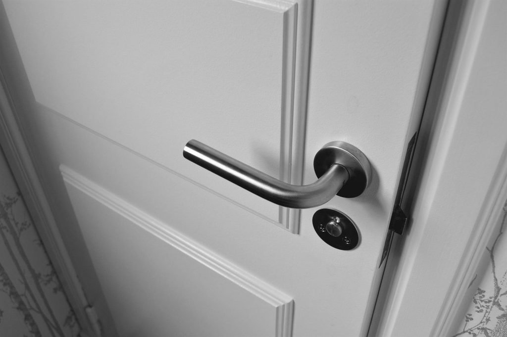 White interior door with a modern lever handle that will not latch shut