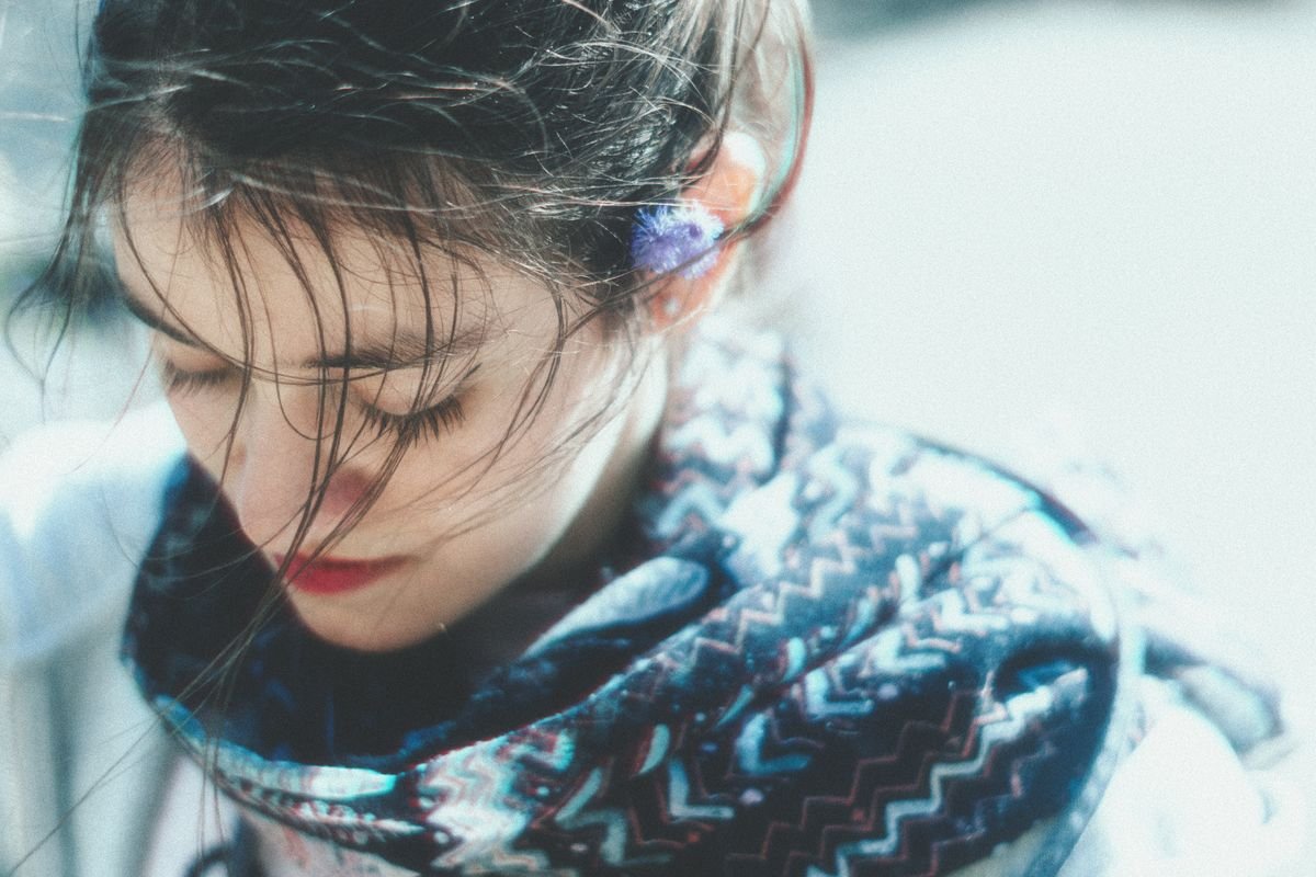 Close up portrait of a woman wearing a woolen winter scarf pulled up against the cold